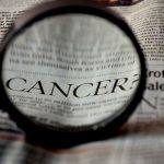 bericht in de krant vergroot met loupe cancer